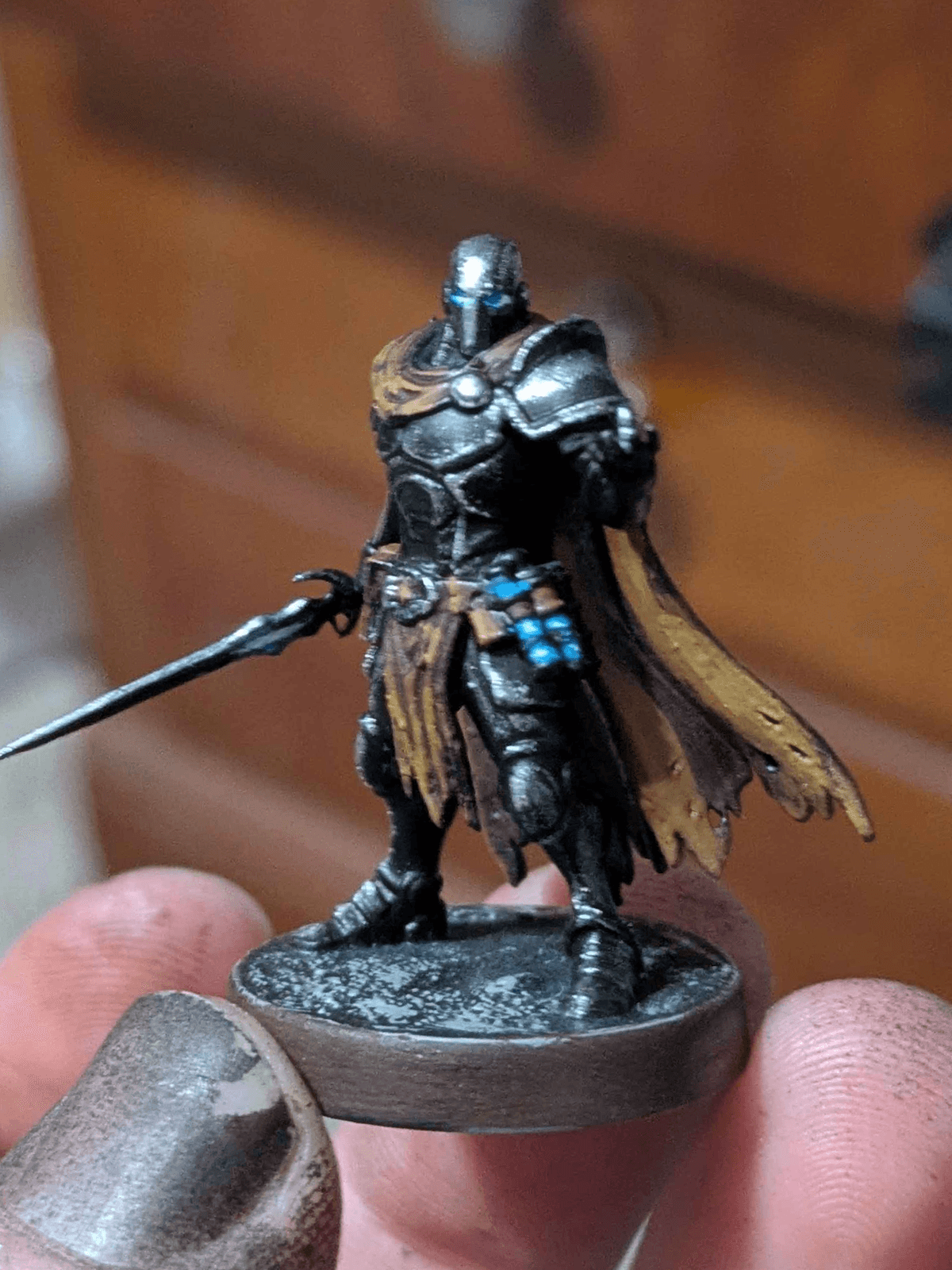 Hand-painted space warrior miniature with dark armor, blue eyes, and a tan cape