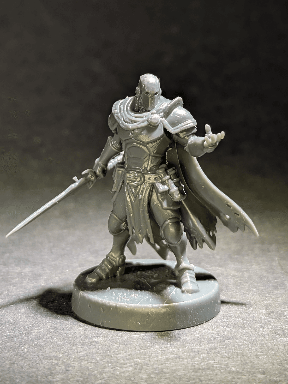 Unpainted armored space warrior miniature with a sword and cape